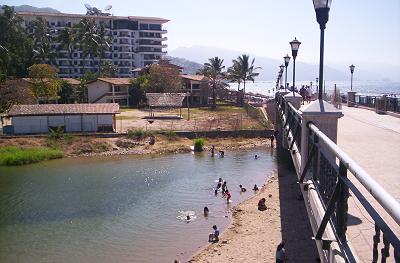 Cildren swimming in mouth of Rio Cuale by Malecon crossing