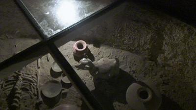 Escort Dog figurine beside skeleton in ancient tomb